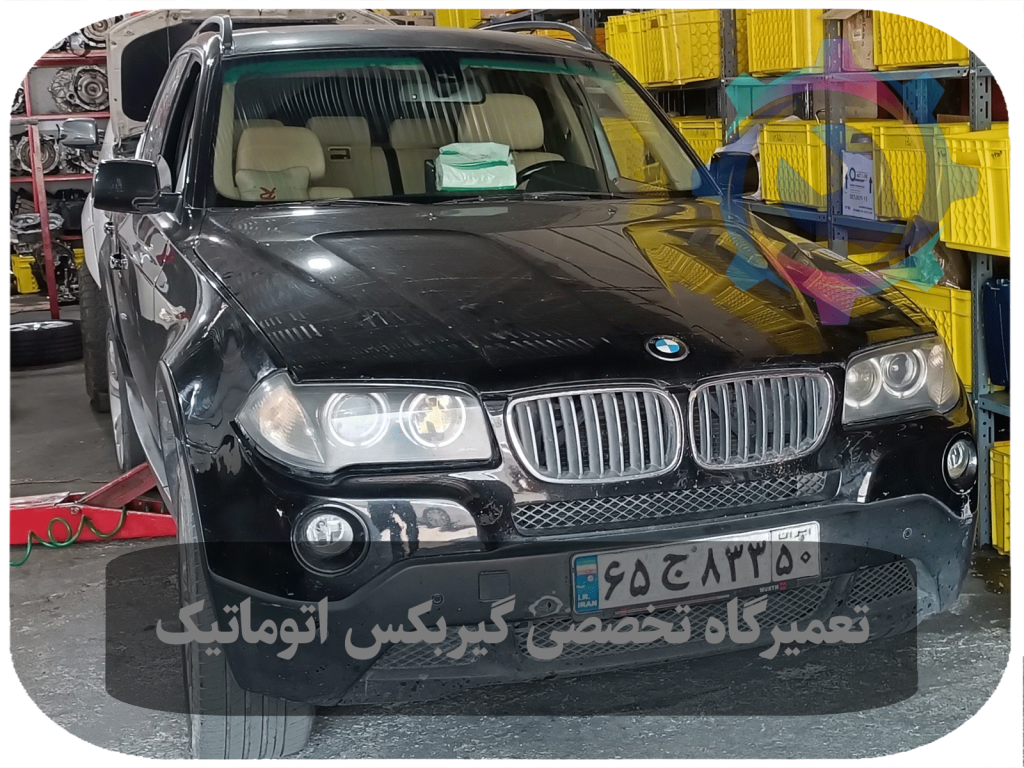 تکنسین مشغول بررسی گیربکس اتوماتیک BMW X3 با استفاده از دستگاه تشخیص پیشرفته.