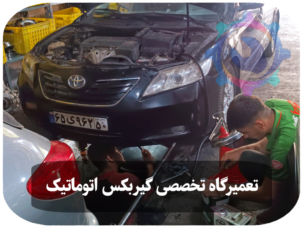 تصویری از یک تکنسین خودرو که در حال تعویض روغن گیربکس تویوتا کمری است.
